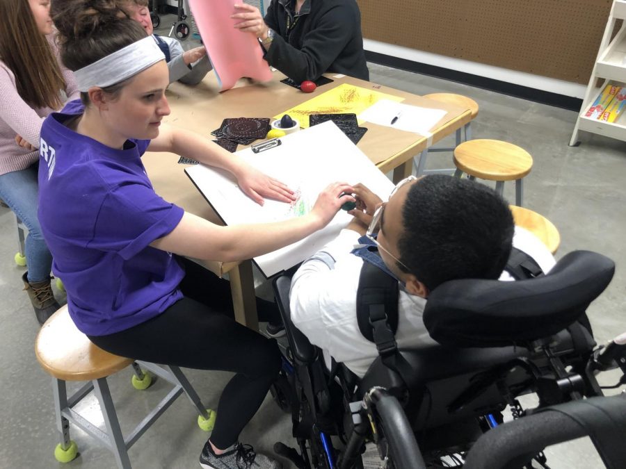 Students work on an art piece during a trial of the adaptive art class