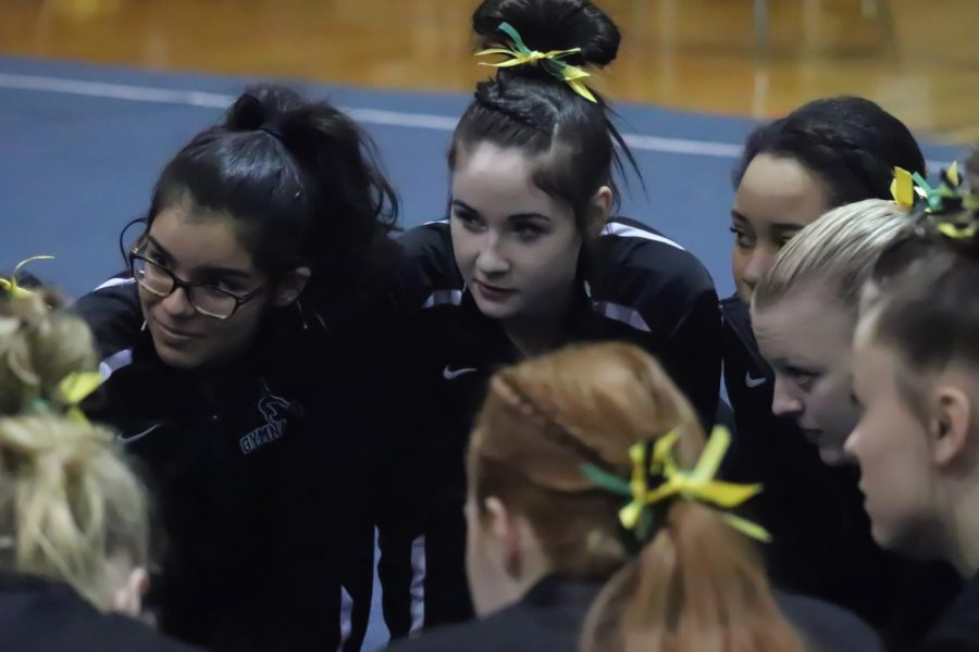 The Warstangs huddle together to do their pre-meet chant. The girls edge out the Wildcats 133.2-125.8