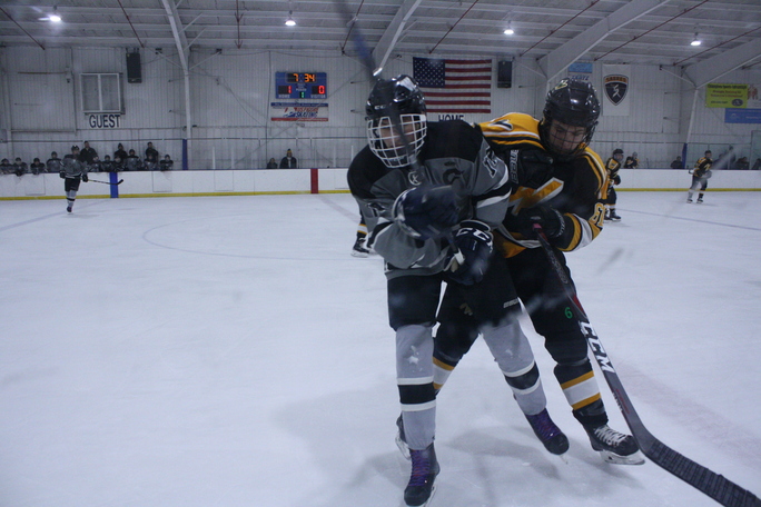 Players aim to claim the puck during the first period.