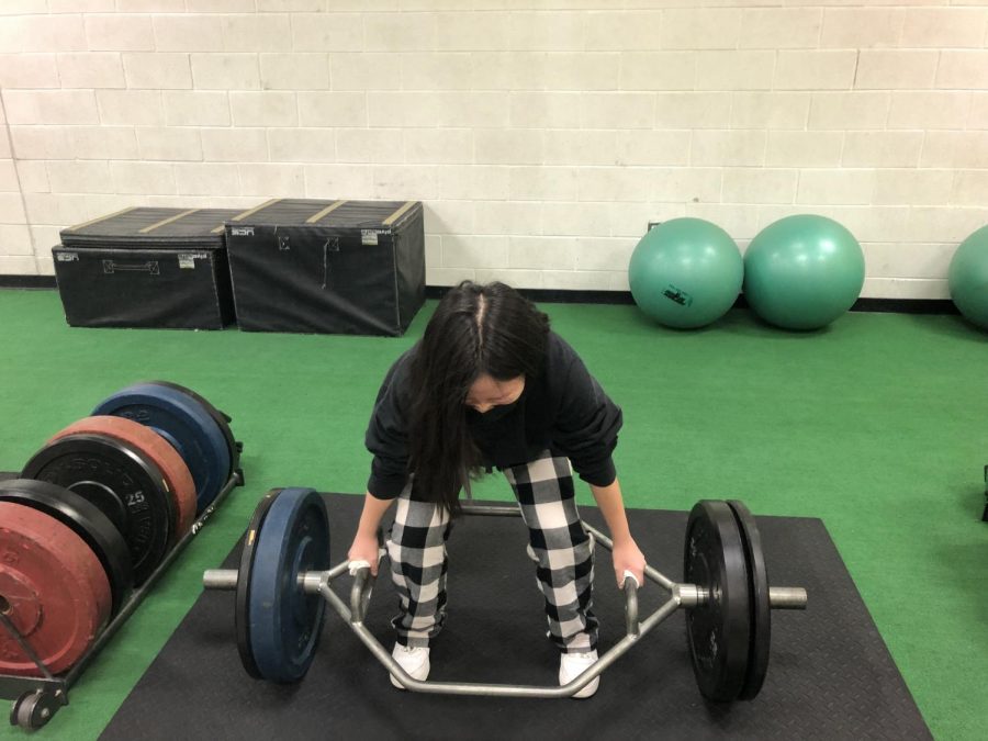 Junior Melissa Kim is about to perform the hex bar deadlift during MPT class to find her training max. 
