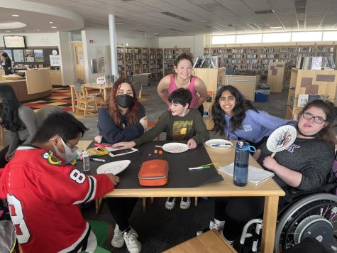 A table full of members of Best Buddies has fun making crafts in the library during a meeting. 