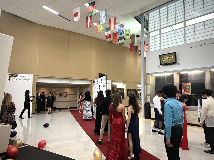 Students line up to take photos with each other infront of the backdrop.