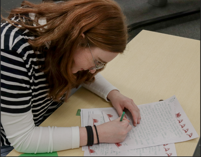 Senior Annika Kmiecik writes a letter from Santa to give to one of the children. 