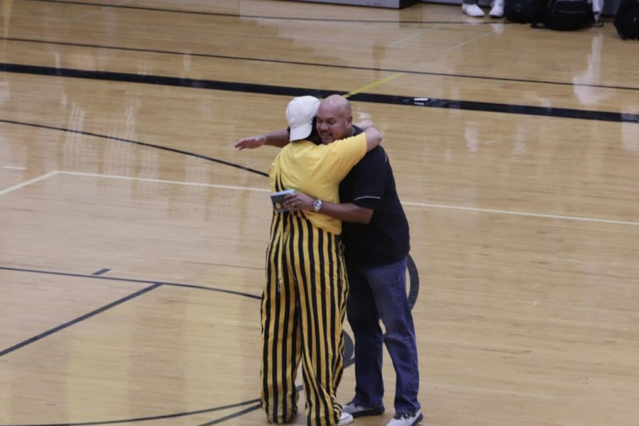 Principal Dr. Echols gives MC Saad Qureshi a hug after receiving a retirement gift from the Mustangs 