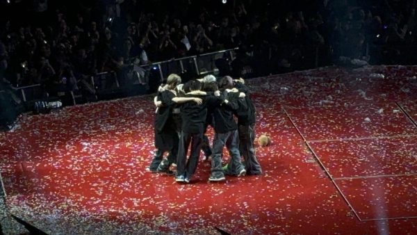 The encore of the ENHYPEN concert with confetti and strings flowing down from the ceiling and the band hugging each other after another successful show. 