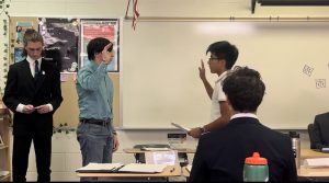 The clerk asks the witness to raise his right hand to be sworn in.