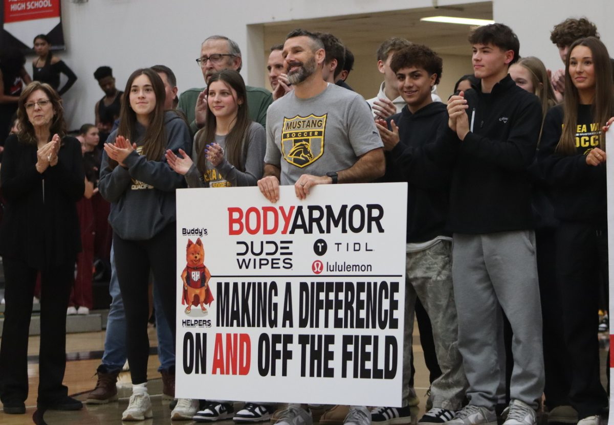 Coach Robinson, students, and his family stand as he receives his award and speeches, awarding him for his valiant effort in giving back to his community. 
New boost