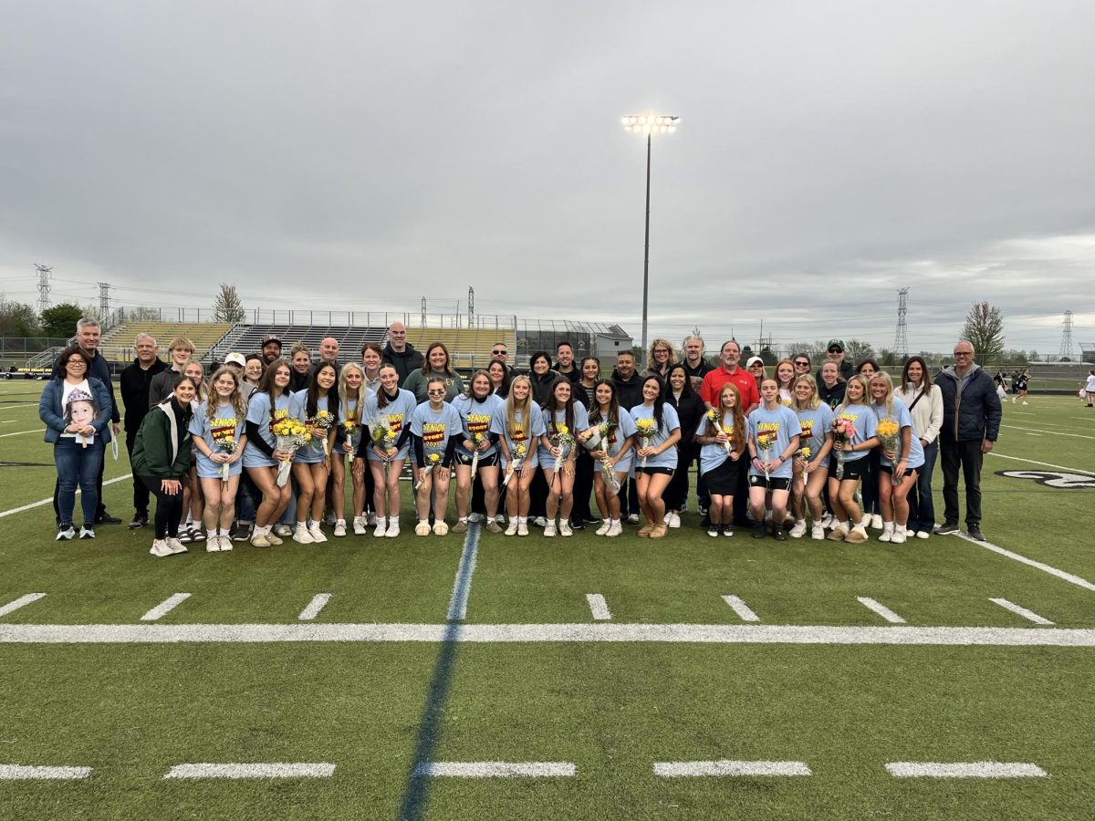 Girls' Valley Lacrosse team posing with joy on Metea Valley's football field