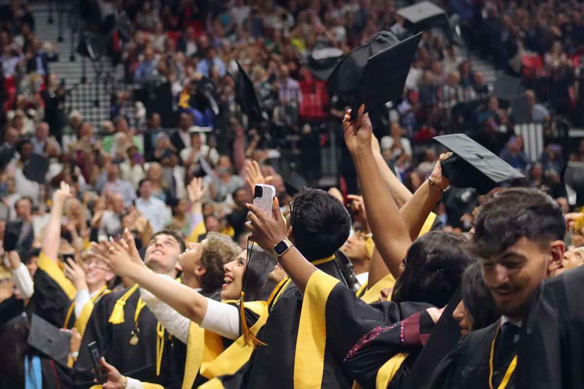 The graduates throw their caps, marking an end to the ceremony. 