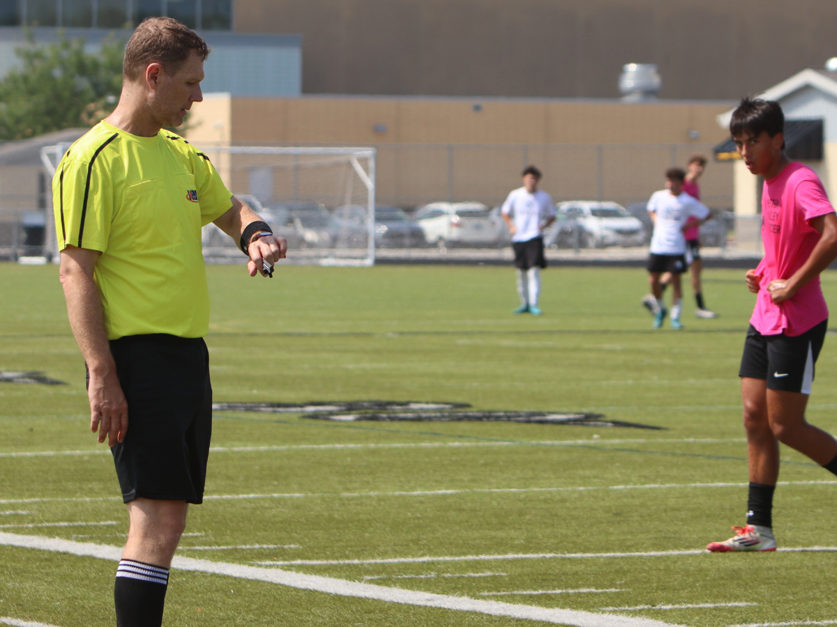 Referee checks watch for time left in the game until halftime.