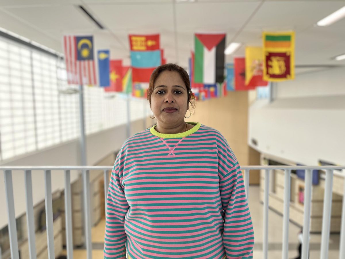 Teachers assistant Sunanda Das standing in front of Metea’s flag gallery.
