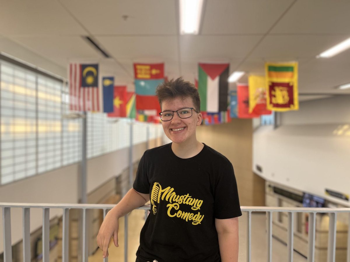 Senior Tommy King standing in front of Metea's flag gallery.

