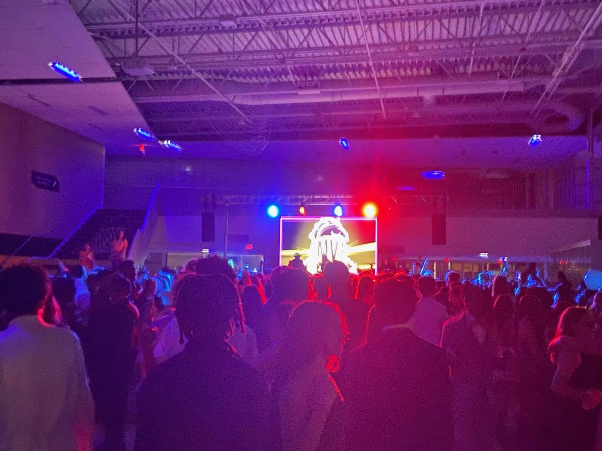 Students stand in a mosh pit on the homecoming dance floor.