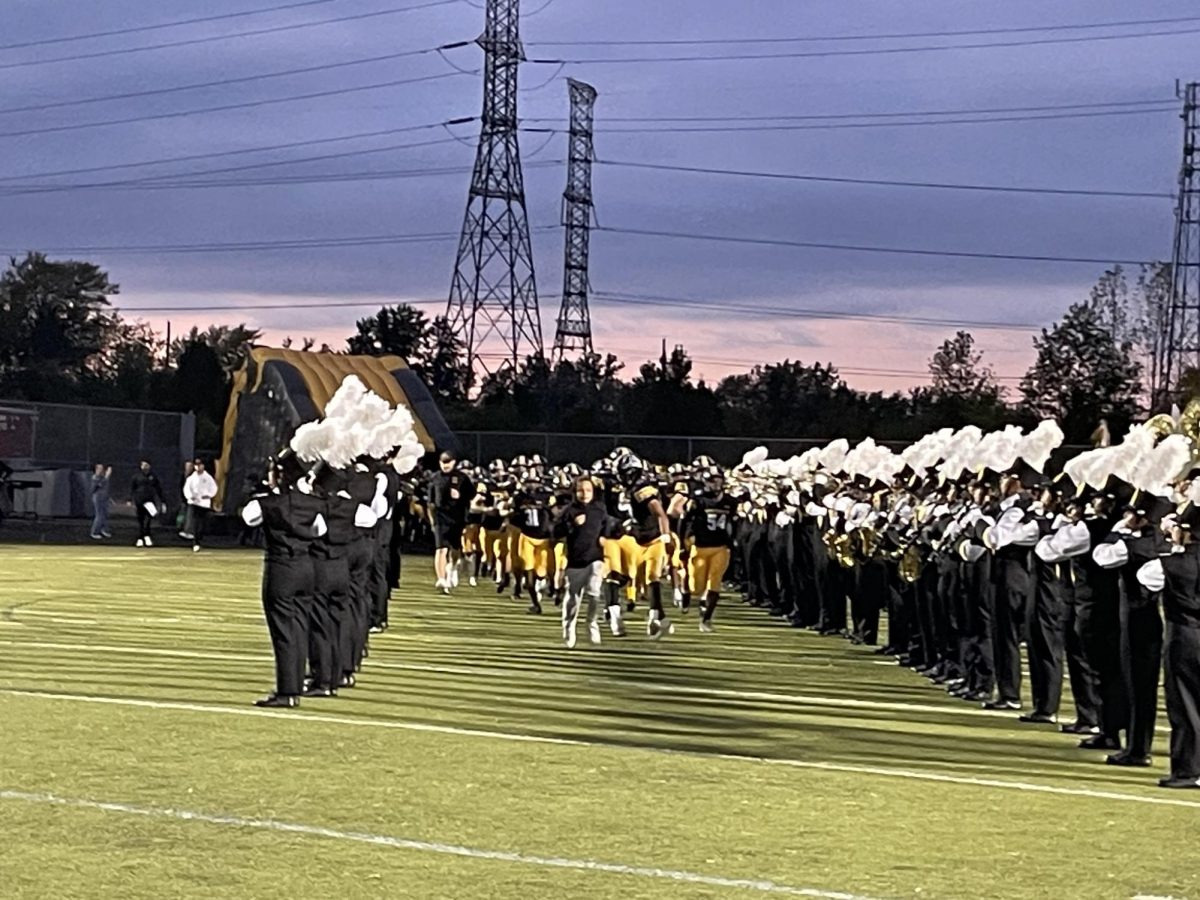 The Metea football team runs onto the field before the homecoming game.