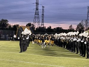 The Metea football team runs onto the field before the homecoming game.