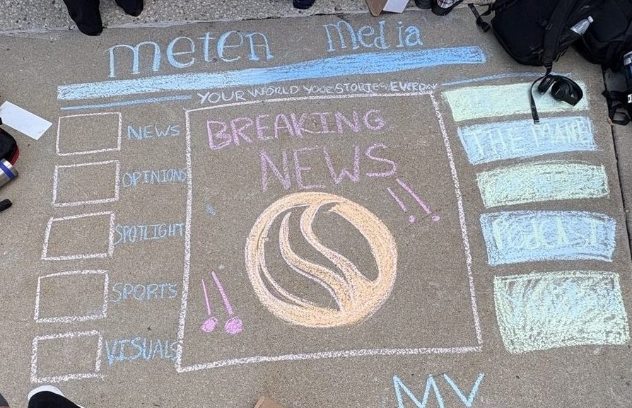 The newspaper journalism staff decorates  a square at Chalk the Walk.