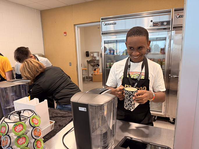 Freshman Marquez Wheeler brews coffee for a customer at Metea Bean.